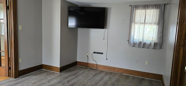 309 5th St SW, Austin, MN 55912 - empty room featuring wood finished floors and a textured ceiling