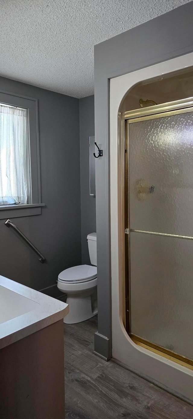 309 5th St SW, Austin, MN 55912 - full bathroom with vanity, wood finished floors, a shower stall, and a textured ceiling