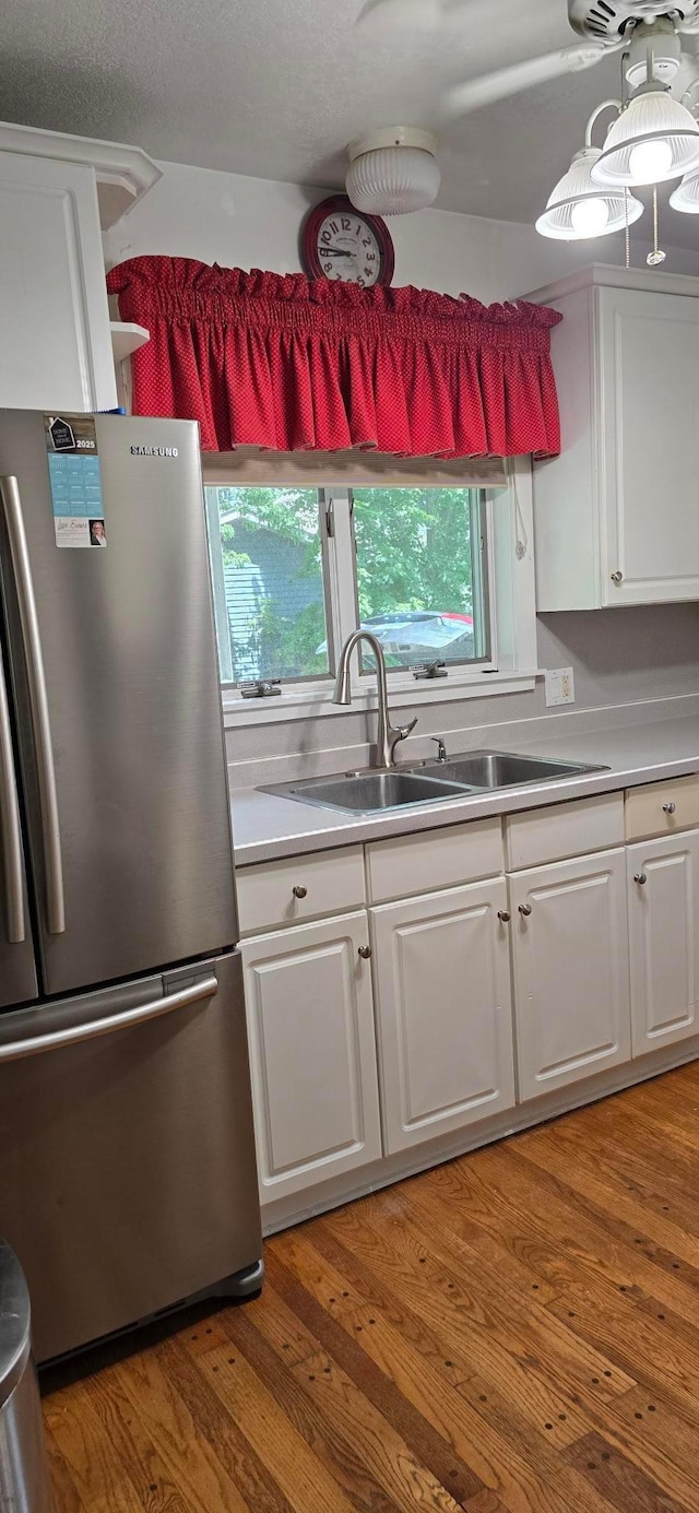 309 5th St SW, Austin, MN 55912 - kitchen featuring freestanding refrigerator, white cabinetry, and plenty of natural light