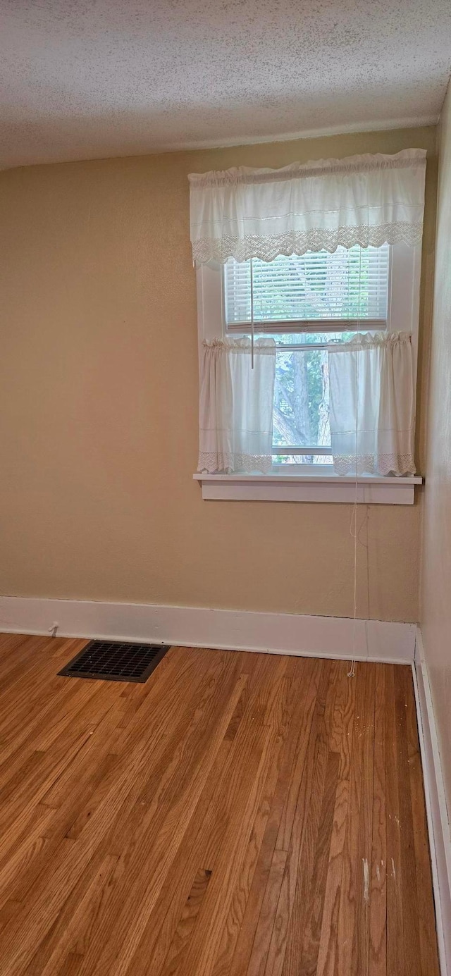 309 5th St SW, Austin, MN 55912 - spare room with wood finished floors and a textured ceiling