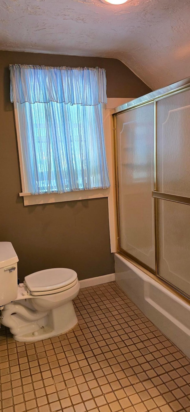 309 5th St SW, Austin, MN 55912 - bathroom featuring bath / shower combo with glass door, tile patterned flooring, vaulted ceiling, and a textured ceiling