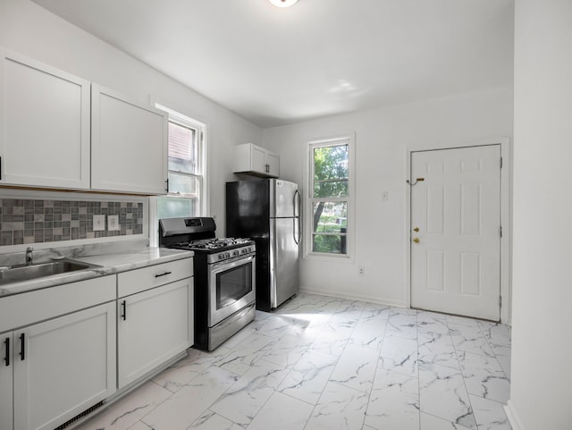 587 Elfelt St, Saint Paul, MN 55103 - kitchen featuring stainless steel appliances, light marble finish flooring, white cabinets, backsplash, and light countertops