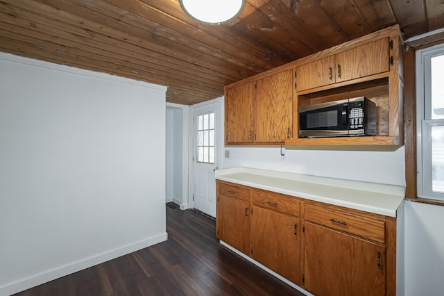 1210 9th St NE, Austin, MN 55912 - kitchen featuring stainless steel microwave, wood ceiling, dark wood-style flooring, light countertops, and brown cabinetry