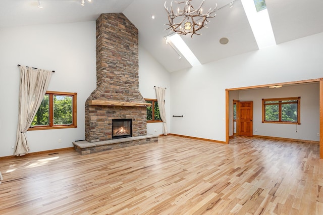 2655 88th Ct W, Northfield, MN 55057 - unfurnished living room featuring high vaulted ceiling, plenty of natural light, light wood-style floors, a chandelier, and a skylight