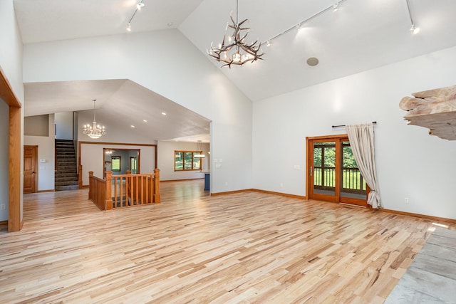 2655 88th Ct W, Northfield, MN 55057 - unfurnished living room featuring rail lighting, a chandelier, plenty of natural light, light wood-style flooring, and high vaulted ceiling