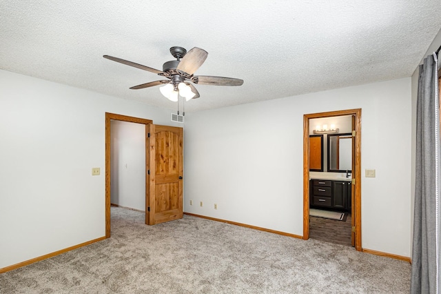 2655 88th Ct W, Northfield, MN 55057 - unfurnished bedroom featuring carpet flooring, a textured ceiling, connected bathroom, and a ceiling fan