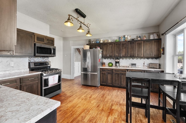 W2741 US Highway 10, Grant Twp, WI 54436 - kitchen with stainless steel appliances, dark brown cabinets, light countertops, decorative backsplash, and a textured ceiling