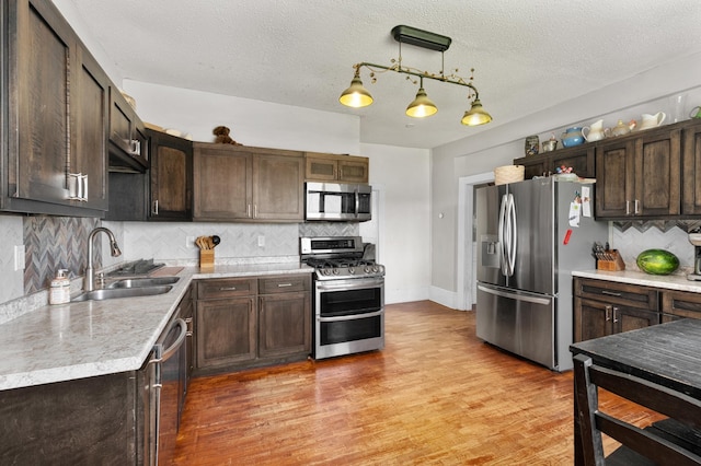 W2741 US Highway 10, Grant Twp, WI 54436 - kitchen with stainless steel appliances, dark brown cabinetry, backsplash, light countertops, and a textured ceiling
