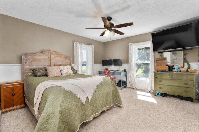 W2741 US Highway 10, Grant Twp, WI 54436 - carpeted bedroom with wainscoting, a textured ceiling, and ceiling fan