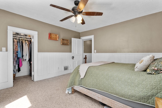 W2741 US Highway 10, Grant Twp, WI 54436 - carpeted bedroom with wainscoting, a closet, a spacious closet, and ceiling fan