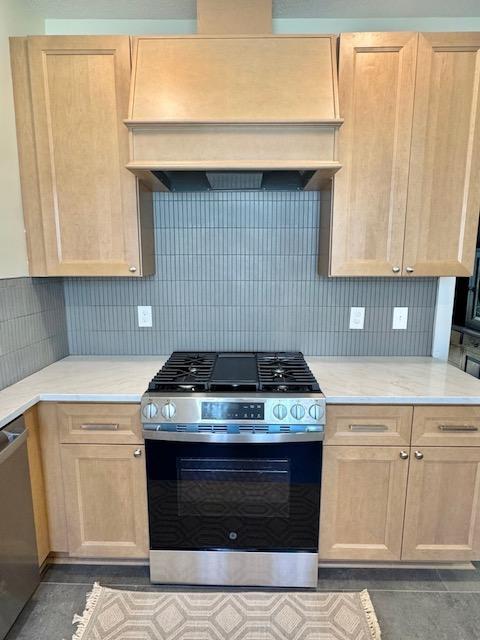 3124 Longfellow Ave, Minneapolis, MN 55407 - kitchen with appliances with stainless steel finishes, custom exhaust hood, light brown cabinetry, and backsplash
