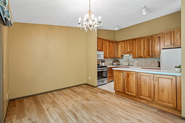 1010 Zanzibar Ln N, Plymouth, MN 55447 - kitchen featuring white appliances, light countertops, a chandelier, tasteful backsplash, and light wood-style floors