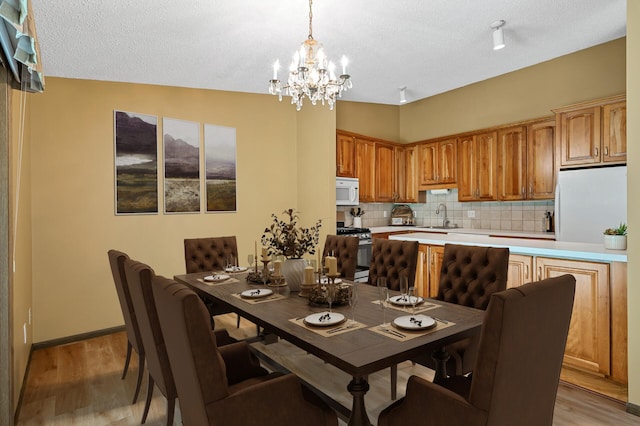 1010 Zanzibar Ln N, Plymouth, MN 55447 - dining area featuring a chandelier, light wood-type flooring, and a textured ceiling