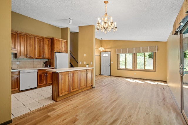 1010 Zanzibar Ln N, Plymouth, MN 55447 - kitchen featuring white appliances, brown cabinetry, light countertops, a textured ceiling, and light wood-type flooring