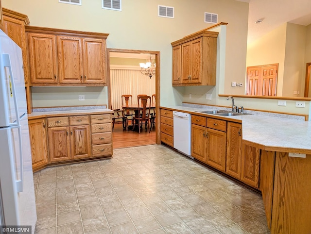 506 6th St SE, Little Falls, MN 56345 - kitchen featuring white appliances, light countertops, a chandelier, a peninsula, and brown cabinets