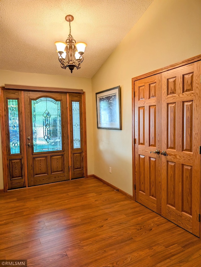 506 6th St SE, Little Falls, MN 56345 - foyer with a chandelier, vaulted ceiling, wood finished floors, and a textured ceiling