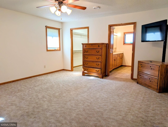 506 6th St SE, Little Falls, MN 56345 - bedroom featuring light carpet, a walk in closet, a textured ceiling, a closet, and ensuite bath