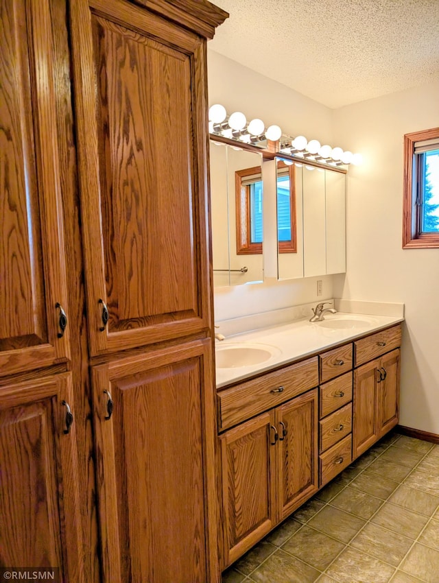 506 6th St SE, Little Falls, MN 56345 - bathroom featuring double vanity, a textured ceiling, and tile patterned floors