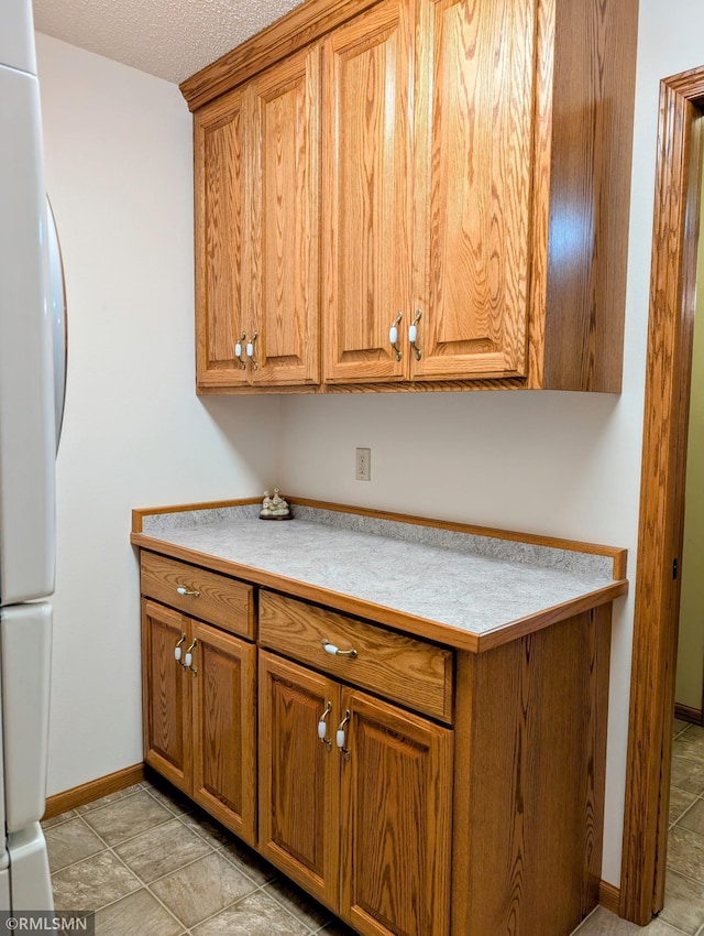 506 6th St SE, Little Falls, MN 56345 - kitchen featuring refrigerator, brown cabinets, and light countertops