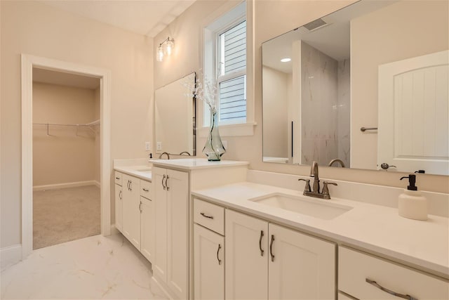 7396 Agate Trl, Inver Grove Heights, MN 55077 - bathroom featuring marble look tiles, two vanities, a walk in closet, and a shower