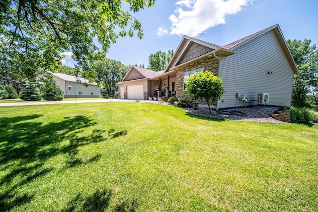 1322 Frontier Rd SE, Salem Twp, MN 55920 - view of side of property featuring a garage, stone siding, a yard, and driveway