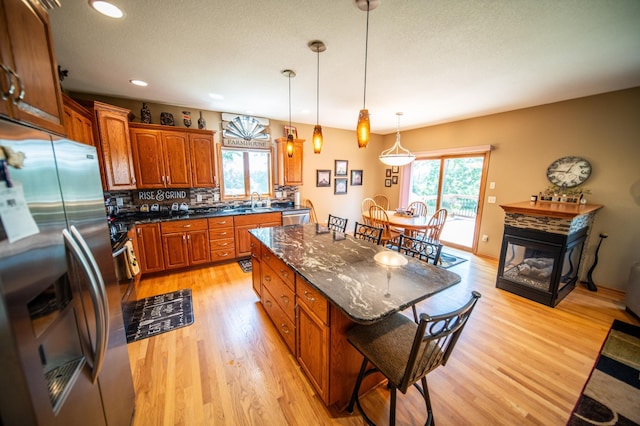 1322 Frontier Rd SE, Salem Twp, MN 55920 - kitchen with stainless steel appliances, healthy amount of natural light, a kitchen breakfast bar, brown cabinetry, and recessed lighting