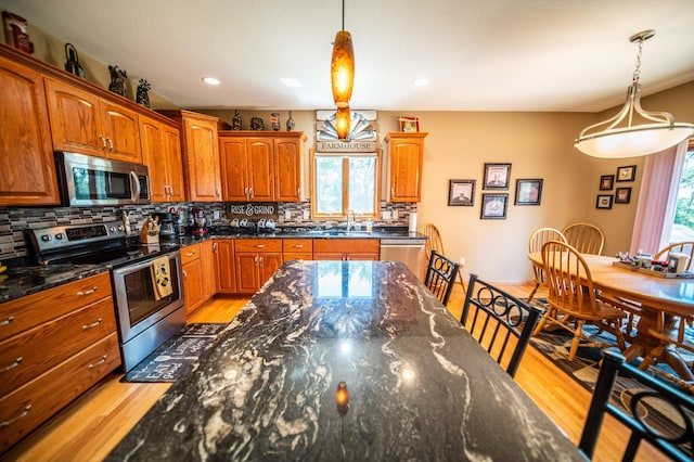 1322 Frontier Rd SE, Salem Twp, MN 55920 - kitchen featuring stainless steel appliances, light wood-type flooring, decorative backsplash, brown cabinets, and recessed lighting
