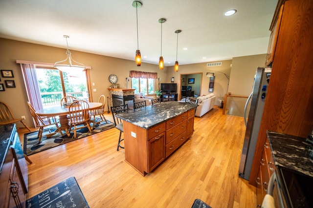 1322 Frontier Rd SE, Salem Twp, MN 55920 - kitchen with brown cabinets, freestanding refrigerator, a breakfast bar area, light wood-style floors, and open floor plan