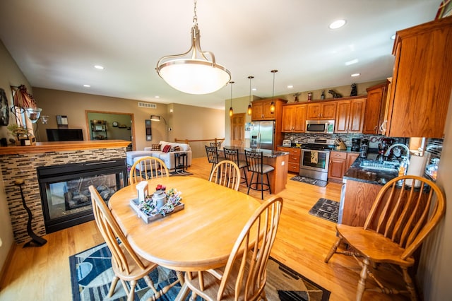 1322 Frontier Rd SE, Salem Twp, MN 55920 - dining space featuring light wood-style flooring, recessed lighting, and a multi sided fireplace