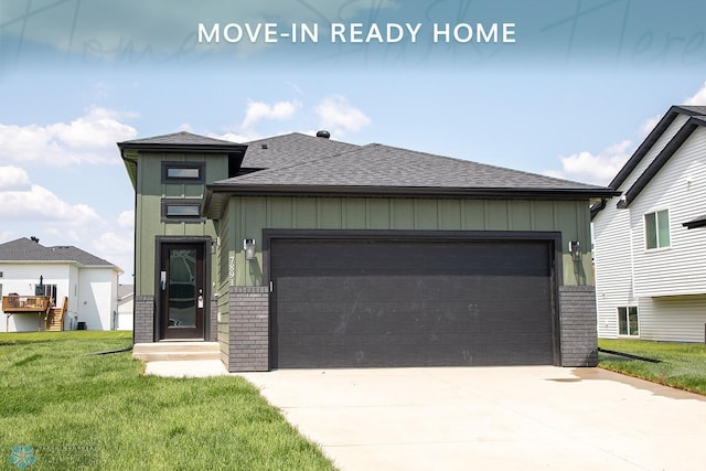 7891 Lost River Rd, Horace, ND 58047 - view of front facade with roof with shingles, a front lawn, an attached garage, board and batten siding, and concrete driveway