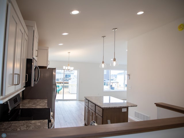 7891 Lost River Rd, Horace, ND 58047 - kitchen with stainless steel appliances, recessed lighting, wood finished floors, a chandelier, and hanging light fixtures