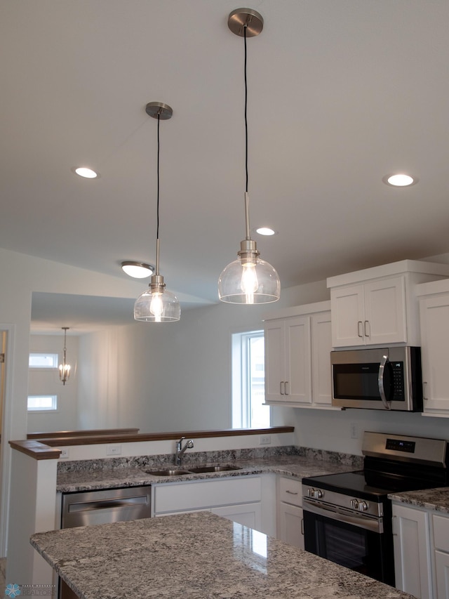 7891 Lost River Rd, Horace, ND 58047 - kitchen with appliances with stainless steel finishes, white cabinetry, recessed lighting, pendant lighting, and light stone counters