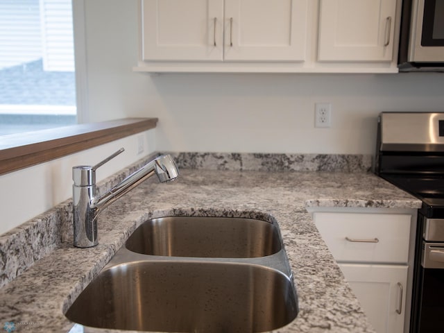 7891 Lost River Rd, Horace, ND 58047 - kitchen with appliances with stainless steel finishes, white cabinetry, and light stone counters