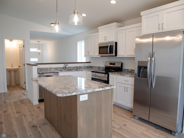 7891 Lost River Rd, Horace, ND 58047 - kitchen with stainless steel appliances, light wood-style flooring, white cabinets, a kitchen island, and recessed lighting