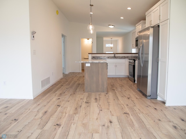 7891 Lost River Rd, Horace, ND 58047 - kitchen with stainless steel appliances, light wood-style flooring, white cabinets, pendant lighting, and a peninsula