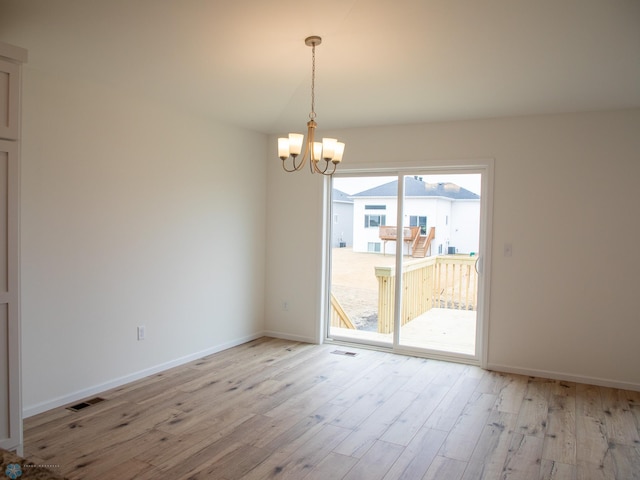 7891 Lost River Rd, Horace, ND 58047 - spare room with light wood-style flooring and a chandelier