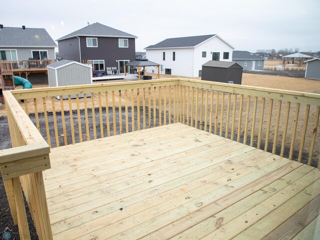 7891 Lost River Rd, Horace, ND 58047 - wooden terrace featuring a storage shed, a gazebo, and a residential view