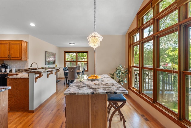 6961 Meadow Ct, Centerville, MN 55038 - kitchen with a kitchen bar, brown cabinets, a peninsula, pendant lighting, and recessed lighting