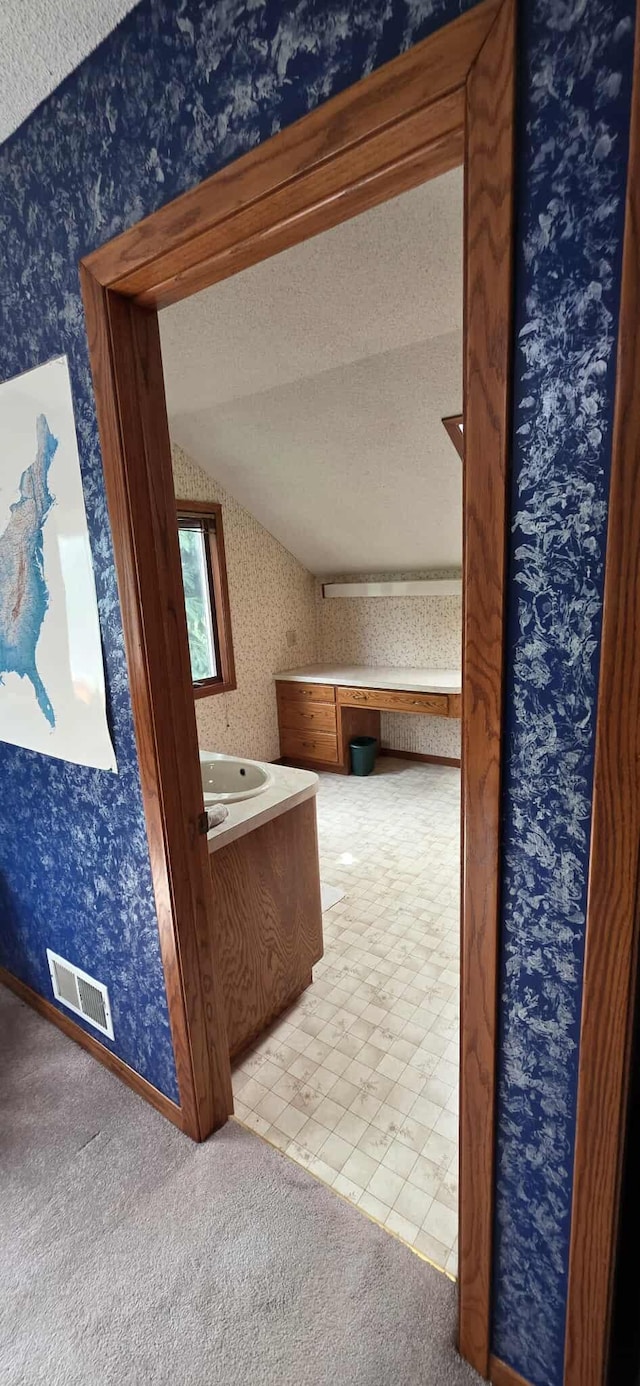 2473 Marshall St, Albert Lea, MN 56007 - bathroom featuring wallpapered walls, vaulted ceiling, a textured ceiling, and vanity
