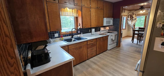 2473 Marshall St, Albert Lea, MN 56007 - kitchen with white appliances, light wood-style floors, healthy amount of natural light, and brown cabinetry