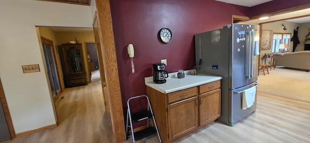 2473 Marshall St, Albert Lea, MN 56007 - kitchen with stainless steel refrigerator with ice dispenser, brown cabinets, light countertops, and light wood finished floors