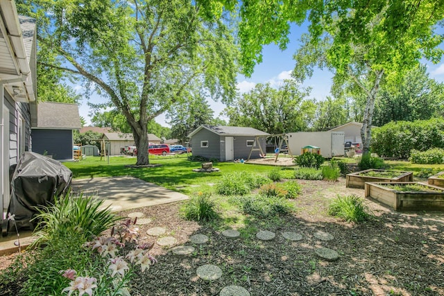 216 1st St SW, Melrose, MN 56352 - view of green lawn featuring an outdoor structure and a garden