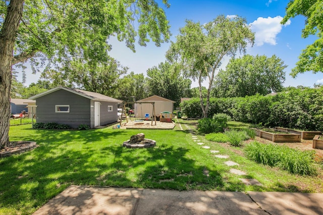 216 1st St SW, Melrose, MN 56352 - view of grassy yard with a vegetable garden, an outdoor structure, an outdoor fire pit, a patio, and view of wooded area