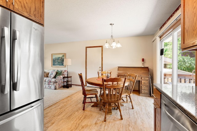 1602 19th Ave SW, Austin, MN 55912 - dining area with light wood-style flooring, a chandelier, and a textured ceiling