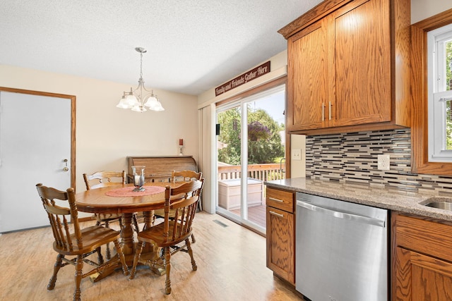 1602 19th Ave SW, Austin, MN 55912 - dining room with light wood-style floors, a chandelier, a textured ceiling, and bar with sink