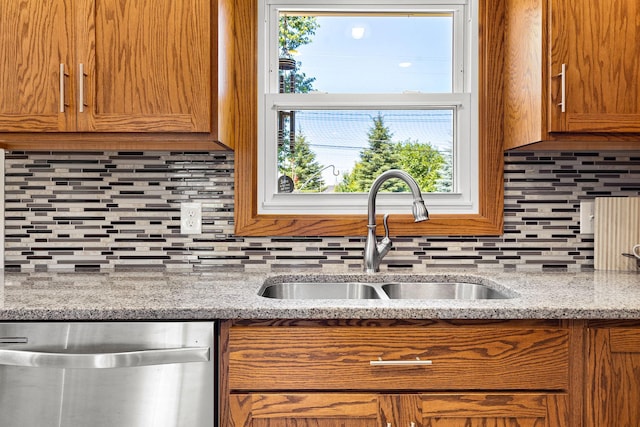 1602 19th Ave SW, Austin, MN 55912 - kitchen featuring stainless steel dishwasher, decorative backsplash, brown cabinetry, and light stone countertops