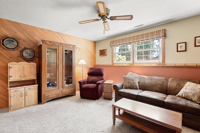 1602 19th Ave SW, Austin, MN 55912 - carpeted living room with wooden walls, a ceiling fan, and a textured ceiling