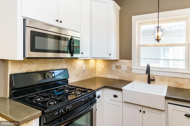 4709 Colfax Ave S, Minneapolis, MN 55419 - kitchen with black gas range oven, stainless steel microwave, dark countertops, and white cabinetry