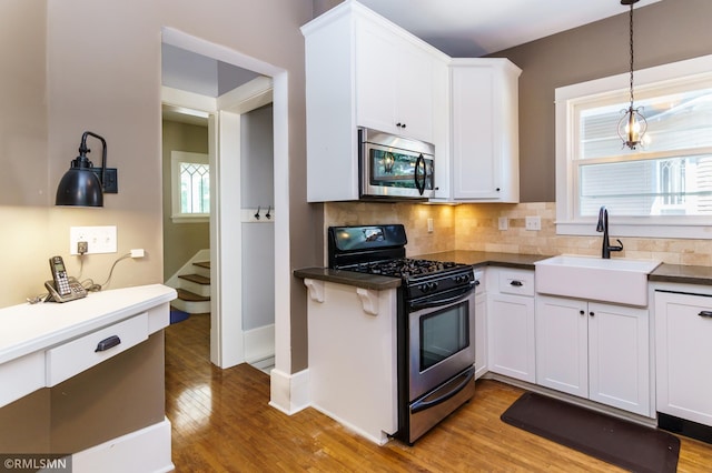 4709 Colfax Ave S, Minneapolis, MN 55419 - kitchen featuring stainless steel microwave, gas stove, white cabinetry, and dark countertops