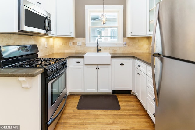 4709 Colfax Ave S, Minneapolis, MN 55419 - kitchen with appliances with stainless steel finishes, white cabinetry, and light wood-type flooring